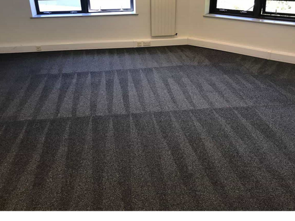 This is a photo of a grey carpet that has just been professionally cleaned by The K&S Carpet Cleaners. The carpet is now in 'as new' condition. The photo was taken on a job in Kent